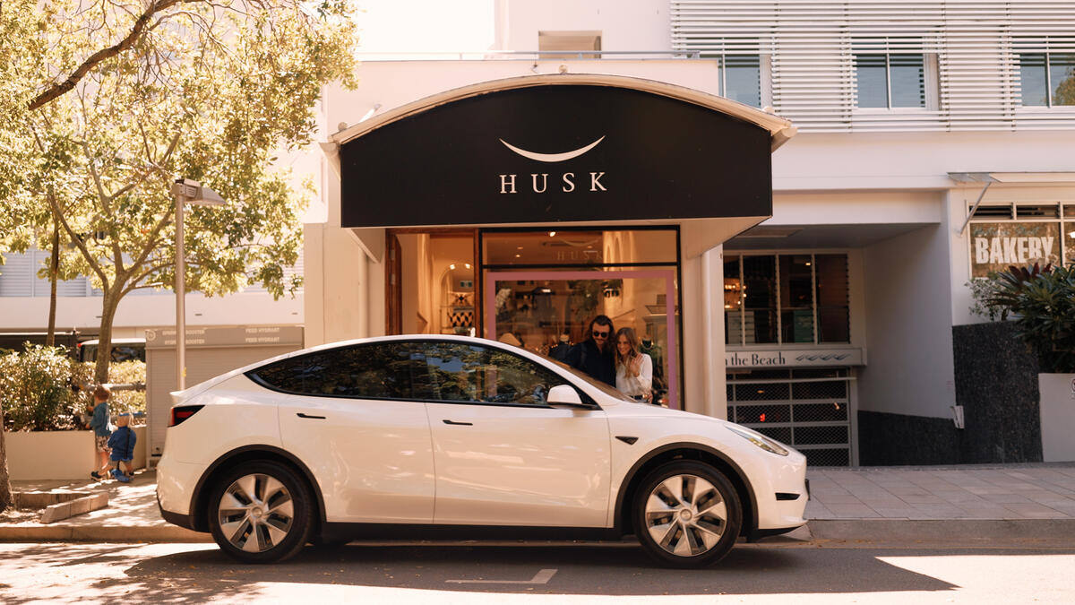 Tesla vehicle on Hastings Street Noosa — premium airport transfer service