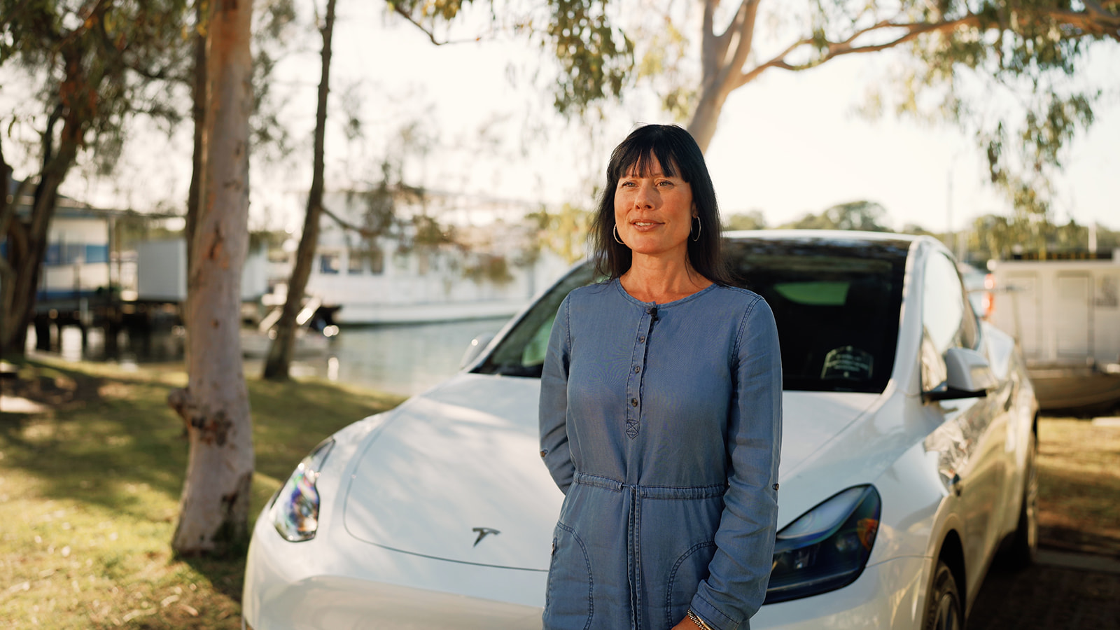 Tesla Transfers Noosa driver beside a white Tesla for a Sunshine Coast Airport transfer